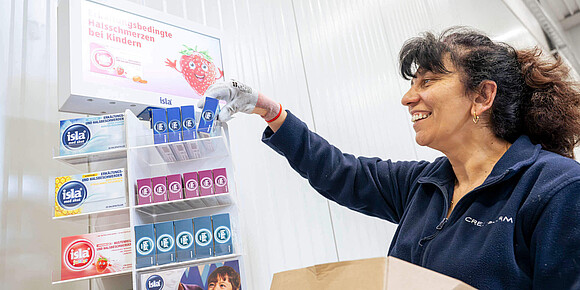 Creopharm Mitarbeiterin sortiert Produkte in einen Display ein
